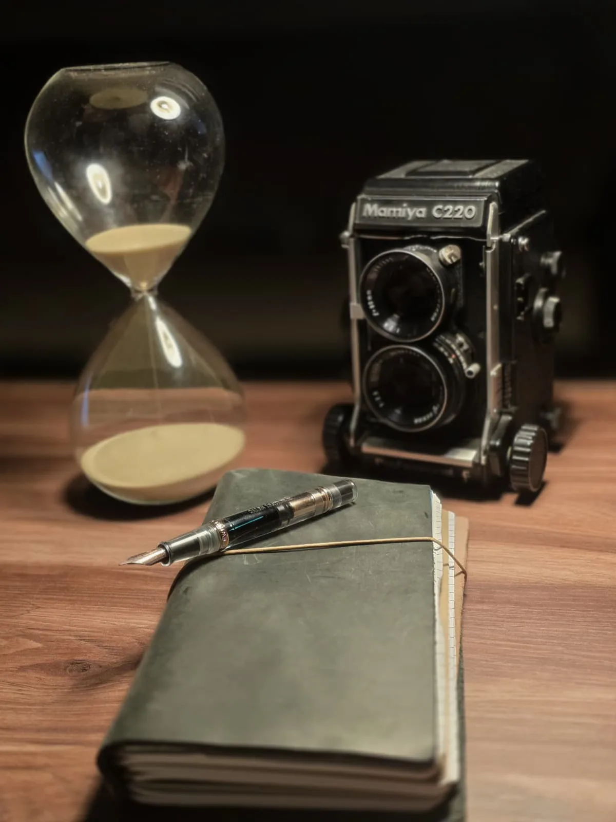 Kum saati, analog fotoğraf makinesi, dolma kalem ve defter